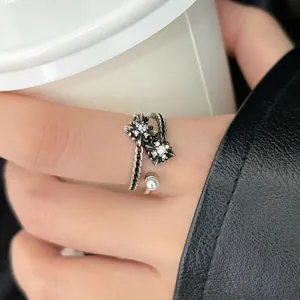 Detail view of a vintage Thai silver open ring featuring floral designs and zircon stones.