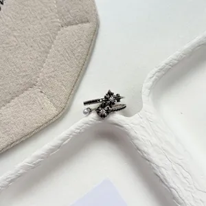 Macro detail of a vintage oxidized silver floral open ring with pearl and cubic zirconia