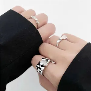 Detailed view of women's irregular silver wrinkled ring with moonstone inlay on fingers.