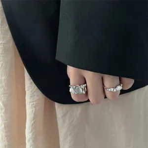 Close-up of minimalist irregular crumpled silver rings with moonstone detail on hand