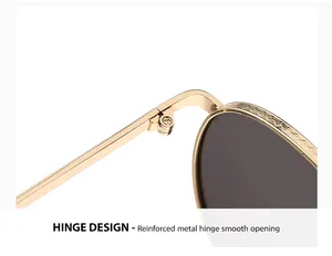 Detail van het versterkte metalen scharnier op de gouden ronde zonnebril voor dames