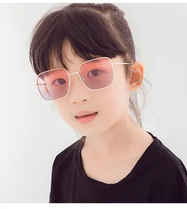 Détail de lunettes de soleil carrées en métal pour enfants avec verres dégradés roses.