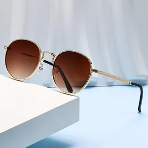 Elegante ronde metalen zonnebril met bruine gradiëntglazen voor premium UV-bescherming.