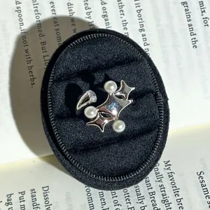 Detailansicht eines silbernen Barock-Rings mit weißen Perlen und funkelndem Stein