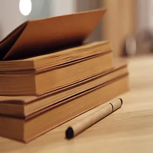 Primer plano detallado de cuadernos de bocetos de papel kraft retro con bolígrafo
