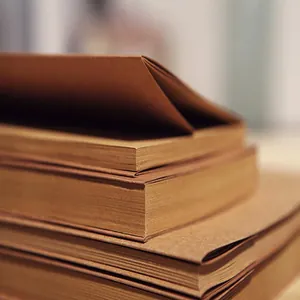 Primer plano de la textura gruesa del papel kraft de cuadernos de bocetos apilados