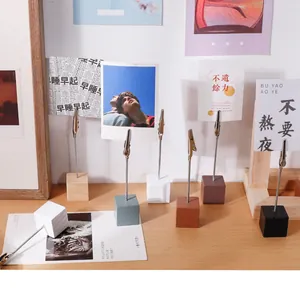 Detailed view of colorful wooden base memo holders with crocodile clips on a desk