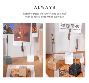 Detail view of wooden base memo clips holding photos and cards on a desk