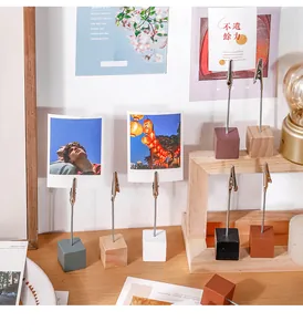 Close-up of colorful wooden block photo clips with alligator clamps holding memories
