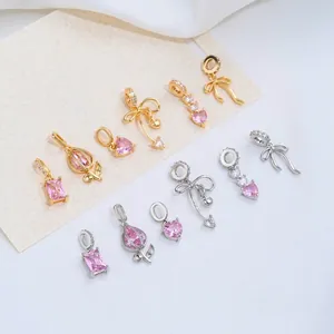 Detalle de colgantes de circón rosa con formas de corazón, tulipán y lazo chapado oro