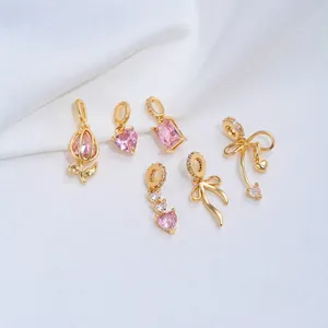 Detalle de colgantes bañados en oro 14K con circón rosa en forma de corazón y tulipán