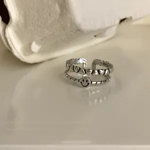 Close-up detail of vintage silver double-layer ring with smiley face and hearts