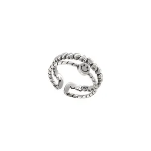 Macro view of double-layer vintage Thai silver ring with engraved smiley face and hearts