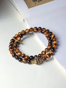 Detail view of Tibetan style double-strand bracelet with tiger's eye beads and bronze focal.