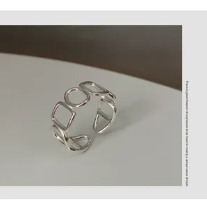 Detaillierte Nahaufnahme eines polierten S925 Silberrings mit geometrischem Hohl-Design.