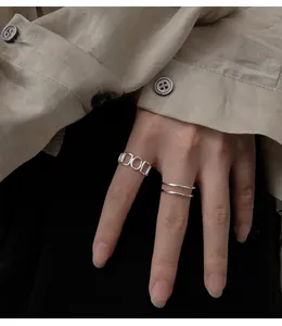 Nahaufnahme von geometrisch hohlen Ringen aus 925er Sterlingsilber an der Hand