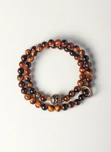 Detailed view of a double-layered tiger's eye beaded bracelet with bronze charm.