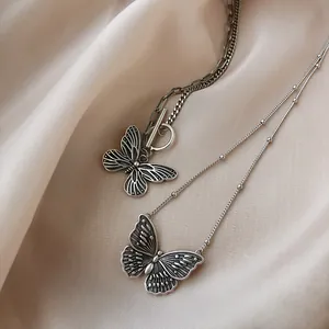 Vintage S925 Sterlingsilber Schmetterling Halsketten auf Satin-Hintergrund