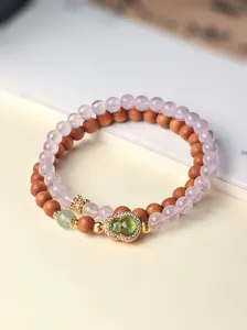 Detail van dubbele streng natuurlijke kristal en sandelhout kralenarmband met kalebas