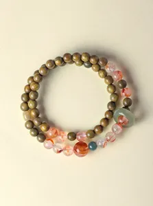 Gedetailleerde macro-opname van een dubbele armband met sandelhout en rode fantoomkwarts.