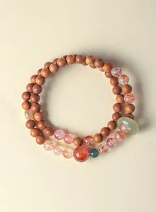 Gedetailleerde weergave van een dubbele lus armband van bloedsandelhout en jade