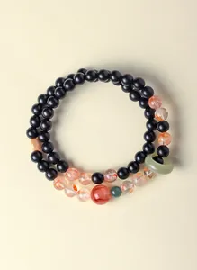 Detailweergave van een dubbellaagse sandelhouten armband met Hetian jade en kwartskralen.