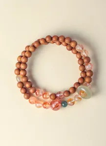 Close-up van dubbellaagse kralenarmband met sandelhout en nephriet jade ring
