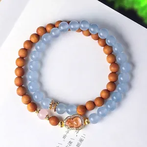 Dubbele armband met blauwe kristal- en sandelhout kralen en kalebas bedeltje