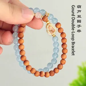Dubbellaagse kralenarmband van sandelhout en blauw kristal met kalebas-bedeltje