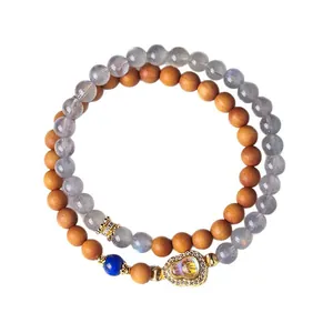 Elegant dubbelstrengs sandelhout en natuursteen armband met gouden kalebas hanger detail