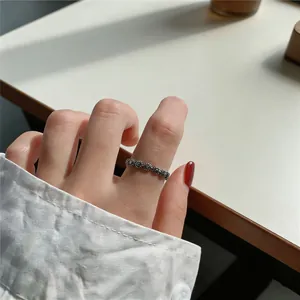 Detailed macro view of a vintage Thai silver floral cross ring on a woman's finger