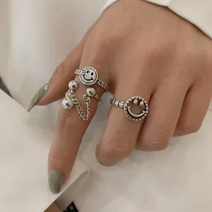 Close-up detail of retro Thai silver open rings featuring smiley faces and chains