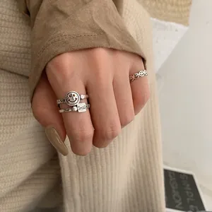Close-up of vintage silver smile rings on hand
