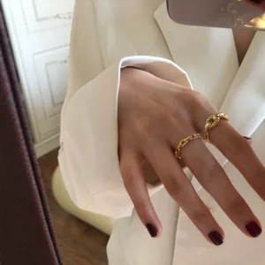 Detailed view of elegant gold-plated sterling silver chain rings worn on a finger.