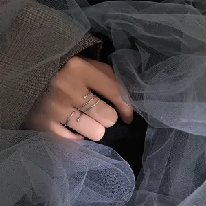 Artistic close-up of a minimalist 925 silver open ring with bamboo texture on a hand