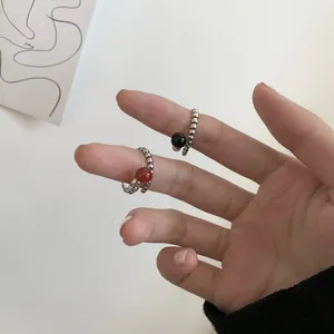 Close-up detail of vintage 925 sterling silver rings with black and red gemstones on a hand