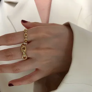 Detail view of s925 sterling silver gold-plated chain link and pig nose rings on finger