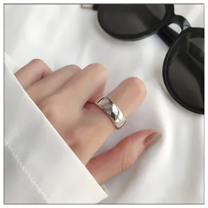 Detailed view of a thick glossy 925 sterling silver open ring worn on the index finger