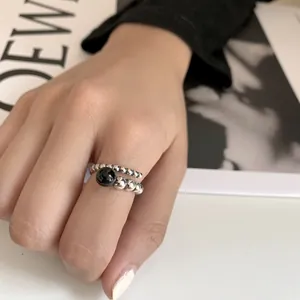 Close-up view of 925 sterling silver ring with black gemstone worn on a model's hand
