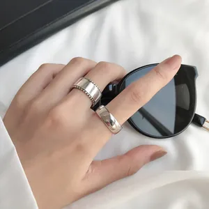 Detailed view of S925 sterling silver minimalist vintage rings on hand with sunglasses.