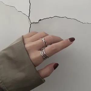 Close-up of minimalist geometric cross open rings in 925 sterling silver for women