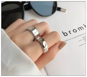Close-up view of thick 925 sterling silver open rings with polished finish and texture.
