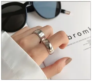 Detail of 925 sterling silver wide smooth ring and beaded edge band for women