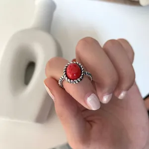 Close-up view of a vintage 925 sterling silver twisted ring with a red oval gemstone