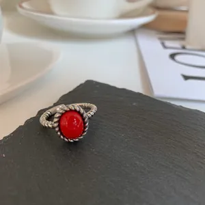 Close-up of vintage 925 sterling silver braided ring with vibrant red oval stone