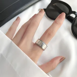 Vintage 925 sterling silver wide band ring with beaded edges shown on a hand model
