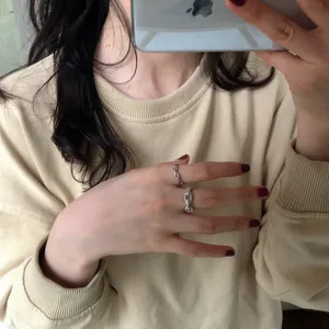 Close-up of S925 sterling silver chain rings and pig nose rings on hand