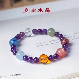 Elegant natural amethyst and multi-gemstone crystal bracelet on an open book background