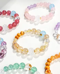 Gros plan de bracelets en quartz rutilé et améthyste faits main avec charme lotus