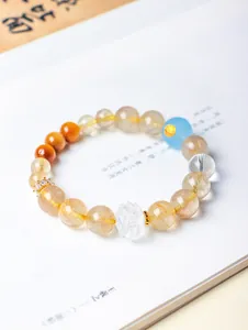 Gros plan d'un bracelet en quartz rutilé doré avec une perle de lotus en cristal sculpté